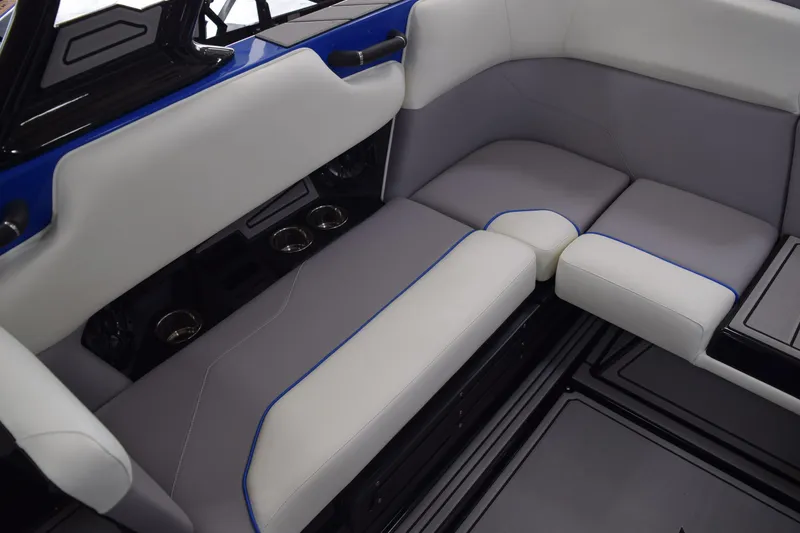 Slide: The Image of 2025 Moomba Max boat interior with gray and white seating, blue accents, and cup holders. - 11