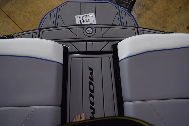 Slide: The Image of 2025 Moomba Max boat interior with gray seating and logo on deck. - 13