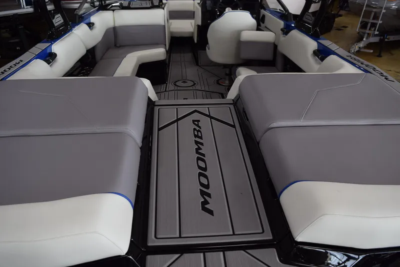 Slide: The Image of 2025 Moomba Max boat interior with gray and white seating, showcasing spacious layout. - 6