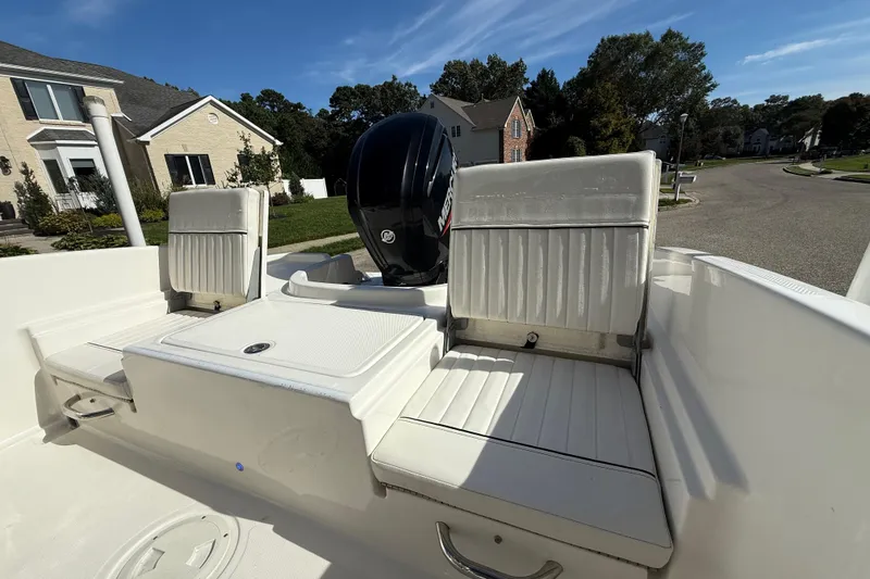 Slide: The Image of 2022 Bayliner Trophy T18Bay boat interior with seating and outboard motor in suburban setting. - 15