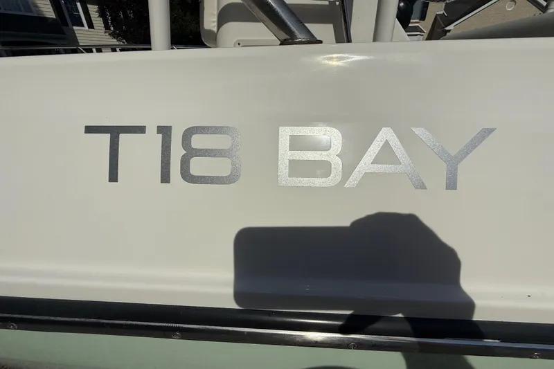 Slide: The Image of 2022 Bayliner Trophy T18Bay boat nameplate in sunlight, showcasing model details. - 17