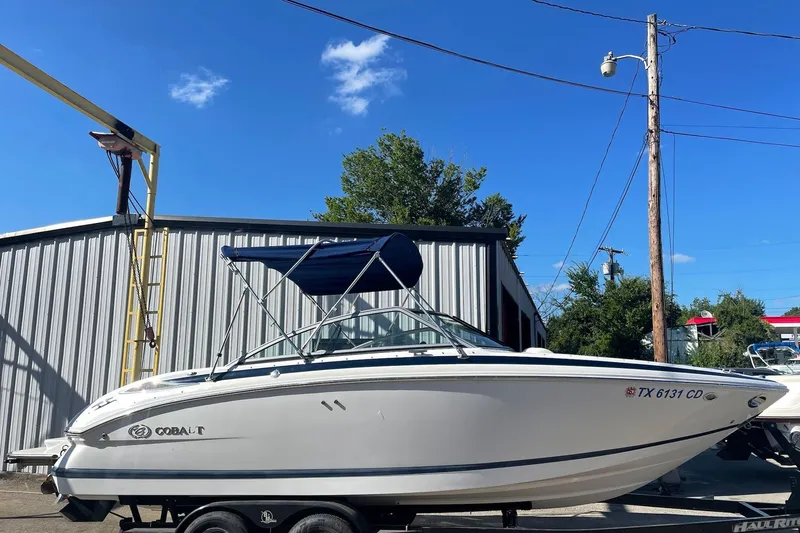 The Image of 2008 Cobalt 212 boat on trailer, parked outdoors under clear blue sky. - 0