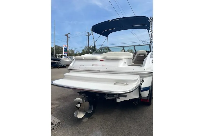 Slide: The Image of 2008 Cobalt 212 boat with blue canopy and visible propeller, parked outdoors. - 6