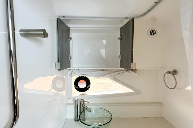 Slide: The Image of 2026 Sea Ray Sundancer 320 bathroom with modern fixtures and open cabinet. - 31