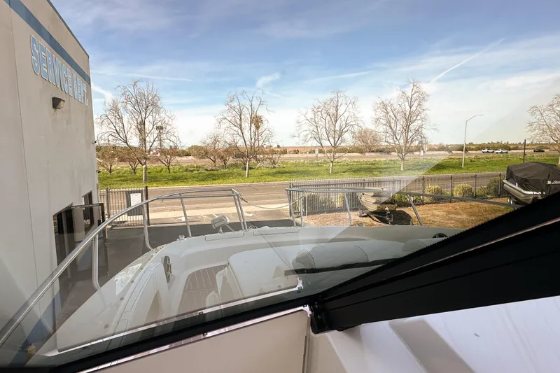 Slide: The Image of 2026 Sea Ray Sundancer 320 at service area, with clear sky and trees in background. - 33