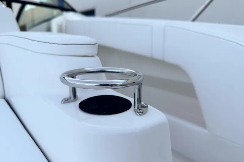 Slide: The Image of 2026 Sea Ray Sundancer 320 boat interior with sleek white seating and chrome cup holder. - 36