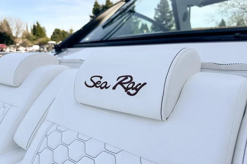 Slide: The Image of 2026 Sea Ray Sundancer 320 boat interior with white leather seating and logo. - 37