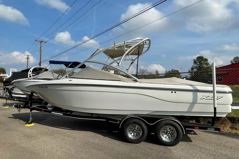 Slide: The Image of 2004 Moomba Mobius XLV boat on trailer, parked outdoors under a blue sky. - 1