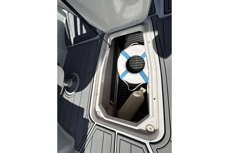Slide: The Image of Open storage compartment on 2020 Monterey M-225 boat with life preserver and fender. - 11