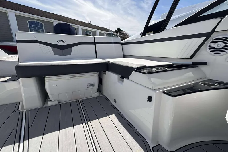 Slide: The Image of 2020 Monterey M-225 boat interior with cushioned seating and built-in storage. - 12