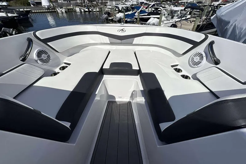 Slide: The Image of 2020 Monterey M-225 boat interior with sleek seating and modern design at a marina. - 4