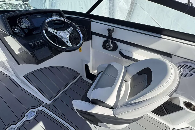 Slide: The Image of 2020 Monterey M-225 boat cockpit with steering wheel, control panel, and cushioned seat. - 5