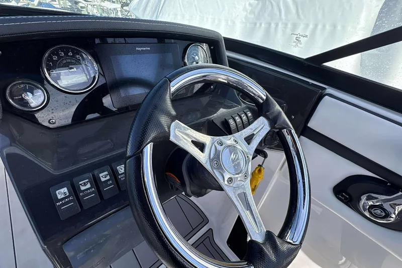 Slide: The Image of Steering wheel and dashboard of 2020 Monterey M-225 boat, featuring gauges and controls. - 6