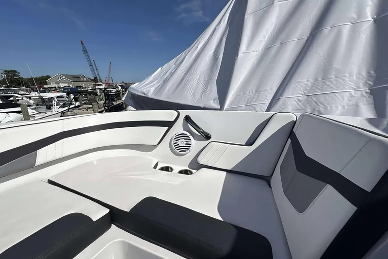 Slide: The Image of 2020 Monterey M-225 boat interior with white and gray seating, docked at marina. - 8