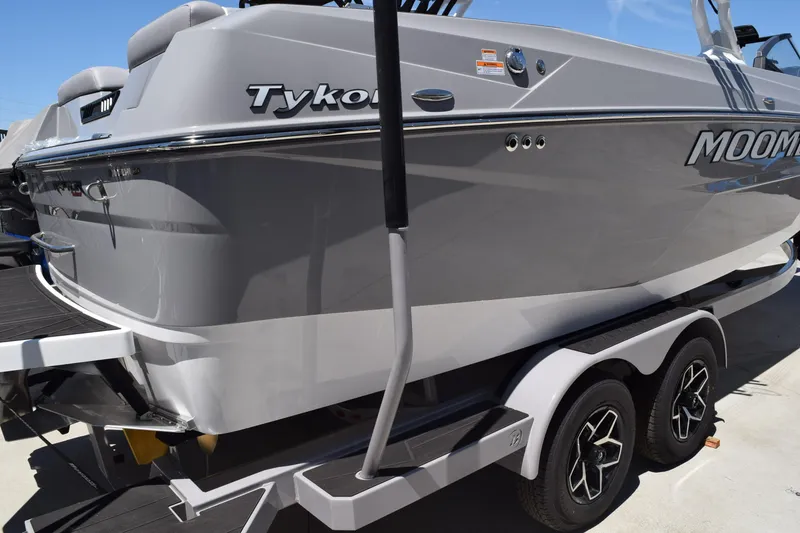 Slide: The Image of 2025 Moomba Tykon boat on trailer, sleek gray design, dual axle wheels. - 1
