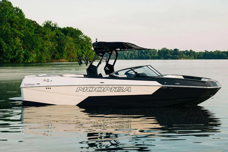 Slide: The Image of Manufacturer Provided Image: 2025 Moomba Tykon boat on a calm lake, surrounded by lush greenery. - 17