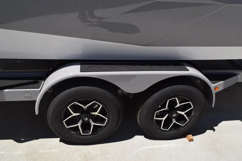 Slide: The Image of 2025 Moomba Tykon trailer with dual black alloy wheels and sleek fender design. - 2