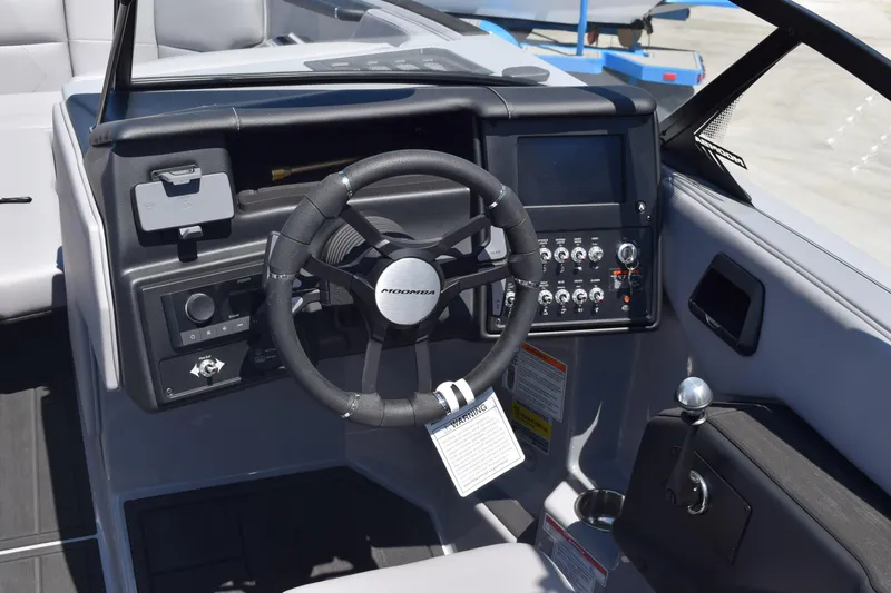 Slide: The Image of 2025 Moomba Tykon boat dashboard with steering wheel and control panel. - 4