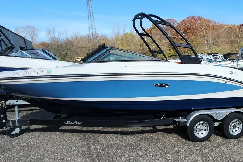 The Image of 2021 Sea Ray SPX 210 Outboard boat on trailer, blue and white design. - 1