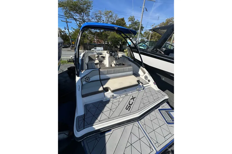 Slide: The Image of 2019 Starcraft Crossover 231 SCX IO SURF boat with blue canopy and spacious seating. - 1