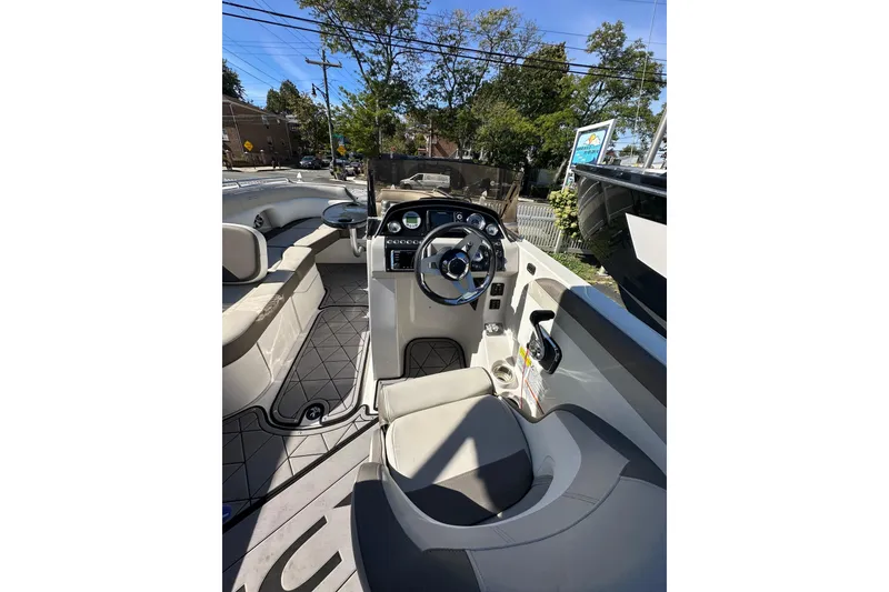 Slide: The Image of 2019 Starcraft Crossover 231 SCX IO SURF boat interior with steering wheel and seating. - 2