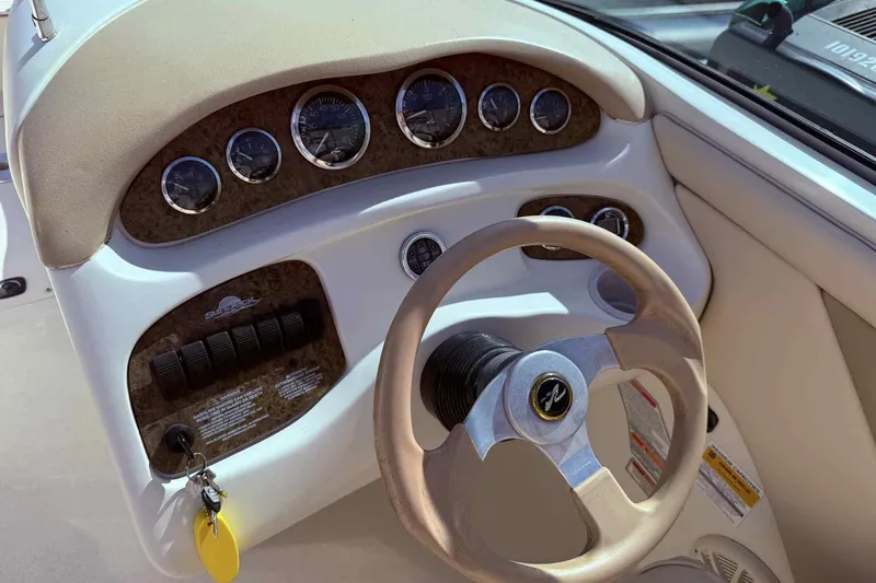 Slide: The Image of Dashboard of a 2000 Sea Ray 210 Sundeck boat with steering wheel and gauges. - 10