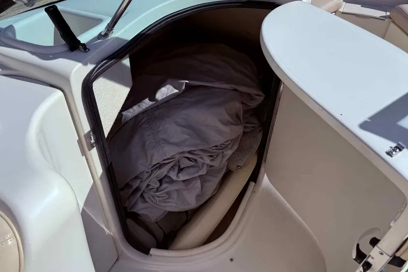 Slide: The Image of Storage compartment on a 2000 Sea Ray 210 Sundeck boat with folded fabric inside. - 14