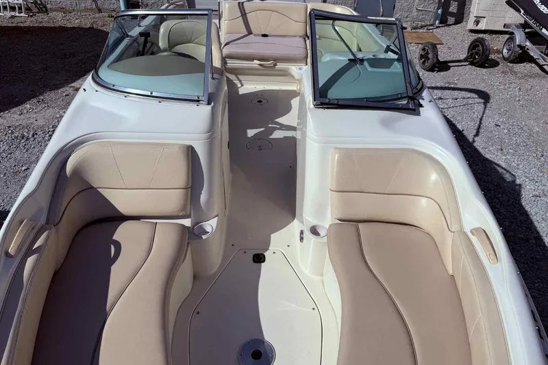 Slide: The Image of 2000 Sea Ray 210 Sundeck boat interior with beige seating and open deck layout. - 16