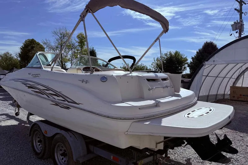 Slide: The Image of 2000 Sea Ray 210 Sundeck boat on trailer under clear blue sky. - 2