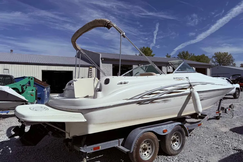 Slide: The Image of 2000 Sea Ray 210 Sundeck boat on trailer, parked outdoors under clear sky. - 4