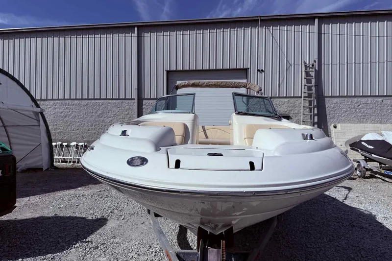 Slide: The Image of 2000 Sea Ray 210 Sundeck boat parked outside a warehouse on gravel. - 6