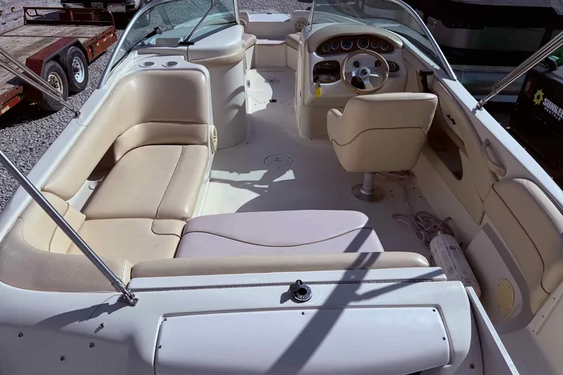 Slide: The Image of Interior of a 2000 Sea Ray 210 Sundeck boat with beige seating and steering console. - 7