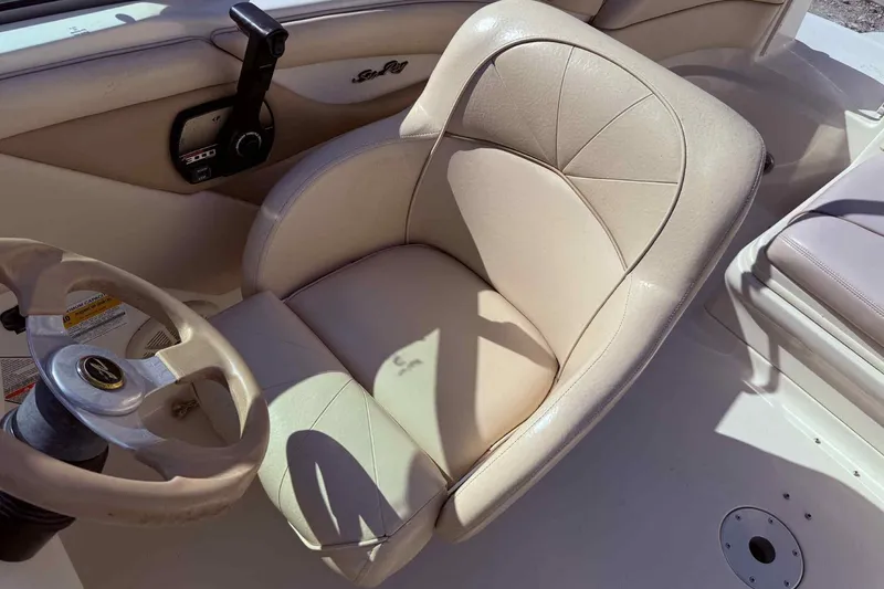 Slide: The Image of 2000 Sea Ray 210 Sundeck boat interior with beige captain's seat and steering wheel. - 9
