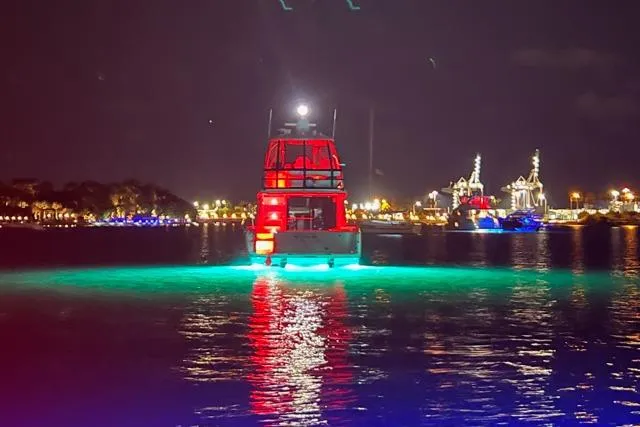 Slide: The Image of 2007 Sea Ray 52 Sedan Bridge yacht illuminated at night on water. - 15