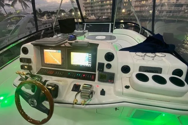Slide: The Image of 2007 Sea Ray 52 Sedan Bridge helm with illuminated controls and navigation screens at dusk. - 16