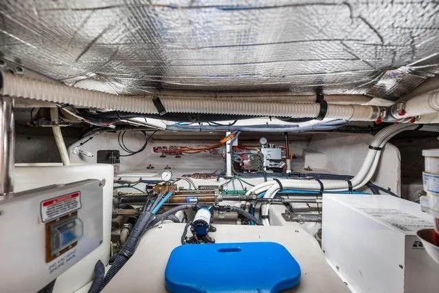 Slide: The Image of Engine room of 2007 Sea Ray 52 Sedan Bridge with visible pipes and equipment. - 28