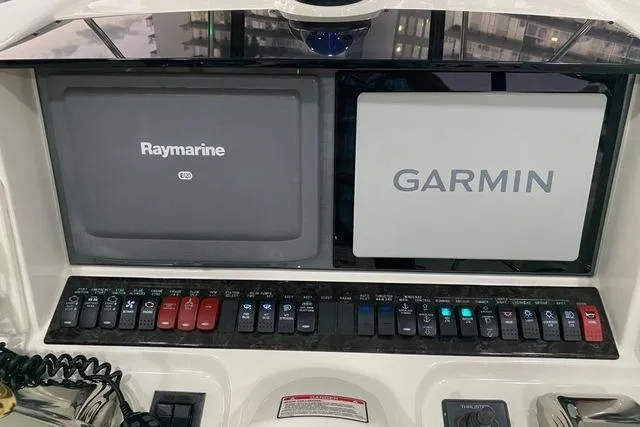 Slide: The Image of 2007 Sea Ray 52 Sedan Bridge dashboard with Raymarine and Garmin navigation displays. - 40