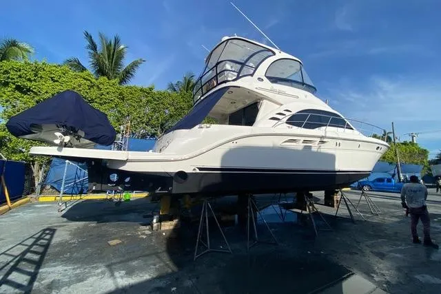 Slide: The Image of 2007 Sea Ray 52 Sedan Bridge yacht on dry dock, surrounded by trees and clear blue sky. - 7
