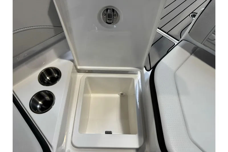Slide: The Image of Open storage compartment on 2026 Sea Ray SPX 210 boat with cup holders. - 21