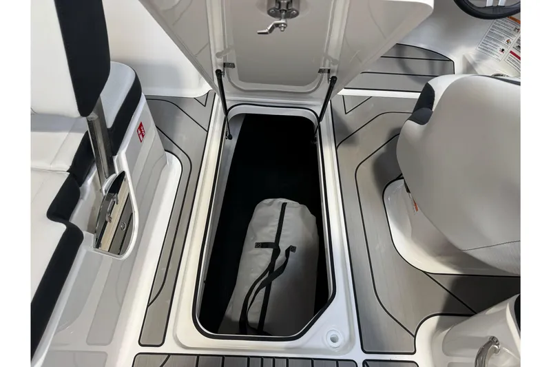 Slide: The Image of 2026 Sea Ray SPX 210 boat storage compartment with bag, featuring sleek interior design. - 24