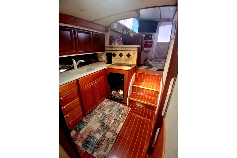Slide: The Image of 1976 Viking 40 Convertible yacht interior with wooden cabinetry and compact kitchen. - 14