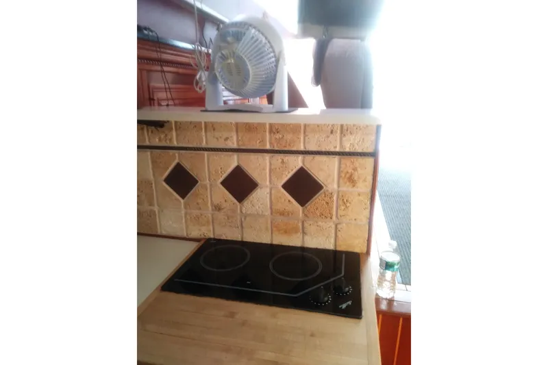 Slide: The Image of 1976 Viking 40 Convertible kitchen with stove, fan, and decorative tile backsplash. - 17