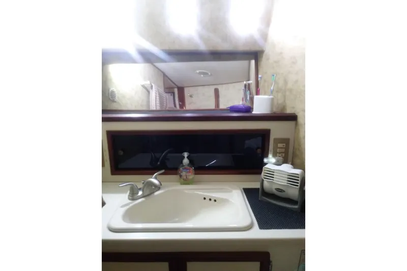 Slide: The Image of Bathroom sink area in a 1976 Viking 40 Convertible boat, featuring a mirror and toiletries. - 24