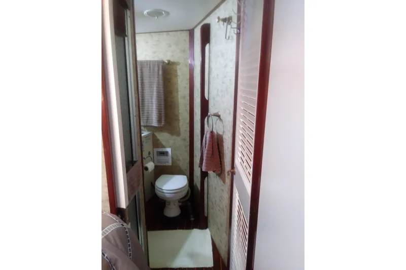 Slide: The Image of Bathroom interior of 1976 Viking 40 Convertible boat, featuring toilet and towel rack. - 25