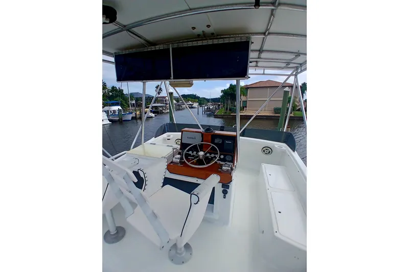 Slide: The Image of 1976 Viking 40 Convertible boat interior with tower, featuring helm and seating. - 4