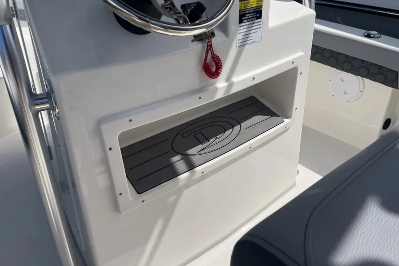 Slide: The Image of Defiance Catalina 210 boat console, featuring storage compartment and steering wheel, 2026 model. - 17