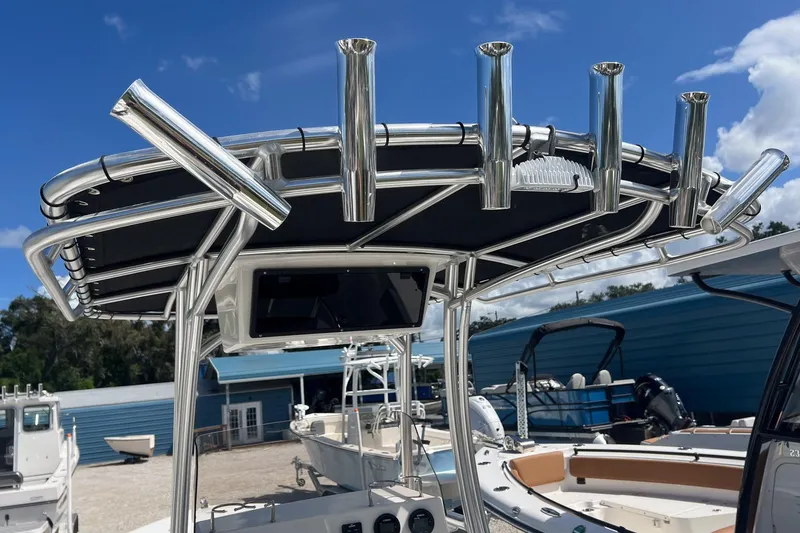 Slide: The Image of 2026 Defiance Catalina 210 boat with stainless steel rod holders and canopy, under a clear blue sky. - 24