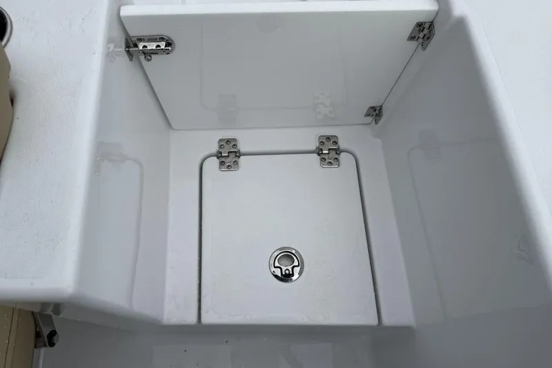 Slide: The Image of 2026 Sportsman Open 212 Center Console storage compartment with secure latch and hinges. - 24