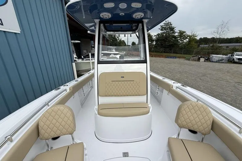 Slide: The Image of 2026 Sportsman Open 212 Center Console boat with beige seating and blue canopy. - 29