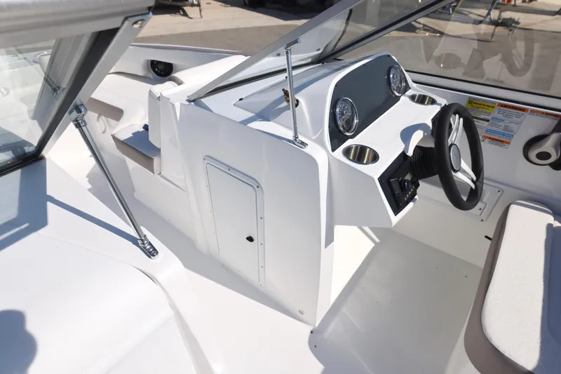 Slide: The Image of 2026 Hurricane SunDeck 235 OB boat at a dealership, surrounded by other boats. - 10